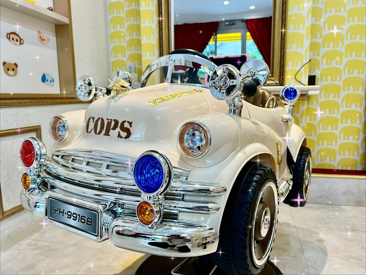 黄色いぞうさんの壁紙の前に置かれたクリーム色の車の椅子